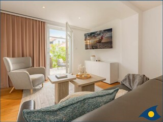 Wohnzimmer mit Schlafcouch und Zugang zur Terrasse