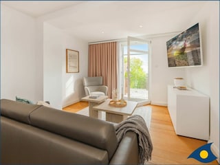 Wohnzimmer mit Schlafcouch und Zugang zur Terrasse