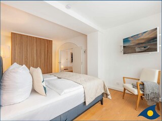 Schlafzimmer mit Doppelbett und begehbarem Kleiderschrank