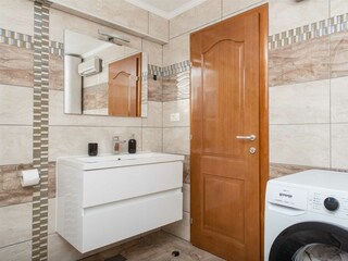 Ein Gemeinschaftsbad mit Badewanne, Trockner und Waschm