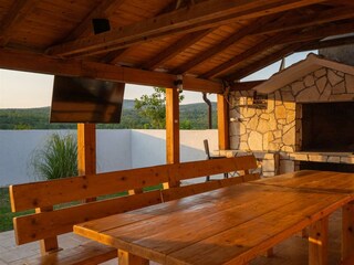 Der überdachte Essbereich im Freien mit Kamin und Kühls