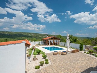 Der überdachte Essbereich im Freien mit Kamin und Kühls