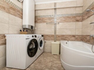 Ein Gemeinschaftsbad mit Badewanne, Trockner und Waschm