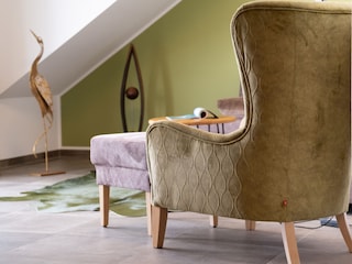 gemütlicher Ohrensessel mit Blick auf den Balkon