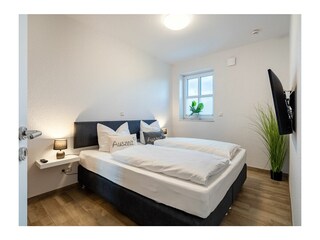 Schlafzimmer mit Boxspringbett im Erdgeschoss