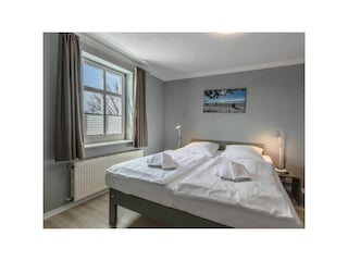 Schlafzimmer mit Doppelbett und Kleiderschrank