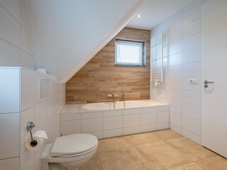 Badezimmer mit Badewanne, Dusche und Toilette