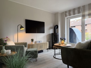 Wohnzimmer mit Kaminofen und 55 Zoll TV