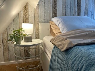 Holzbetontes Schlafzimmer mit eleganter Beleuchtung.