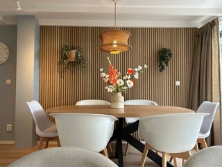 A large dining table with comfortable chairs.