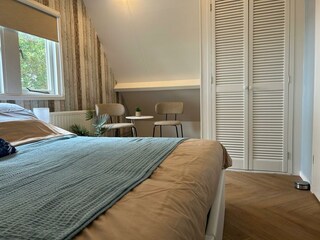 Geräumiger Kleiderschrank mit Klappbett und Bügeleisen.