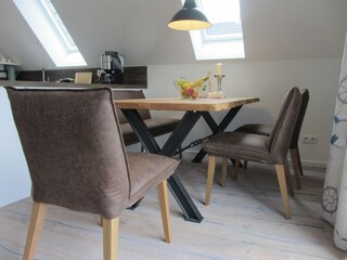 Esstisch mit gepolsterten Stühlen und einer Bank