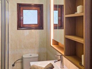 The bathroom has a floor-level shower and