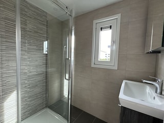 Badezimmer mit großer Dusche und Waschbecken