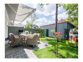 Gartenansicht mit Terrasse und elektrischer Markise