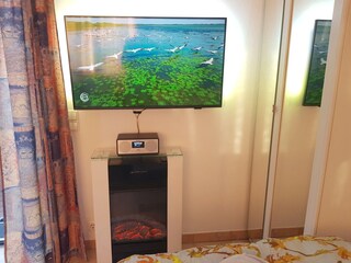 Großer 43 Zoll Smart-TV mit Ambilight an der Wand