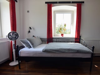 Bett in Wohnzimmer mit Ventilator