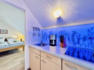 Küchenzeile mit Ceranfeld und beleuchteter Rückwand