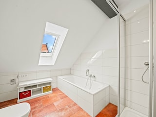 Badezimmer mit Badewanne und Dusche