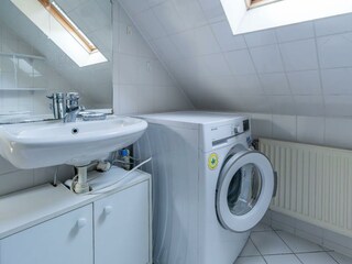 Badezimmer mit Waschmaschine, Dusche und WC