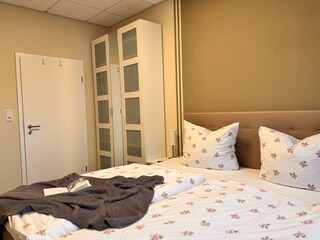 Schlafzimmer mit Boxspringbett und SmartTV