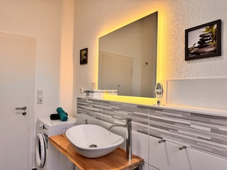 Badezimmer mit Wanne und Waschmaschine