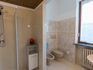 En-suite bathroom with shower, bidet and bright window.