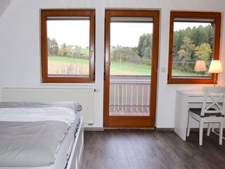 Schlafzimmer mit eigenem Balkon, Schlafsofa und TV