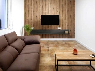 das moderne Wohnzimmer mit TV und separatem Essplatz