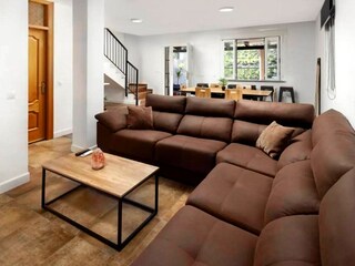 Wohnzimmeransicht mit Sofaecke und Esstisch