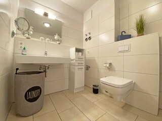 Badezimmer mit Waschbecken und großem Spiegel