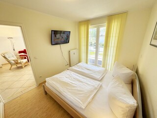 Schlafzimmer mit Doppelbett und TV