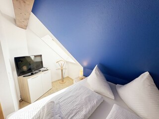 Schlafzimmer mit Doppelbett und Smart-TV