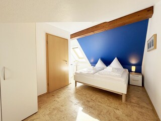 Schlafzimmer mit Doppelbett und Smart-TV