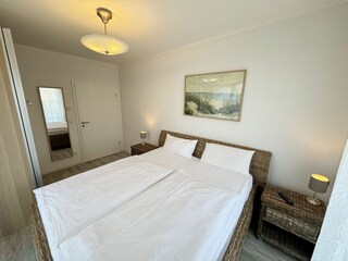 helles und freundliches Schlafzimmer mit Doppelbett