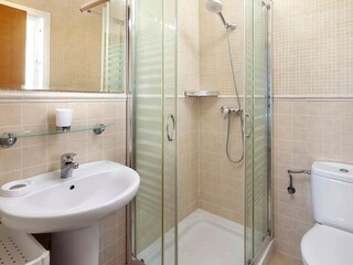 das zweite Bad hat eine Dusche, ein Waschbecken und WC