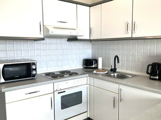 Die Küchenzeile mit Backofen und Mikrowelle.