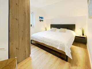 Erstes Schlafzimmer mit komfortablem Doppelbett