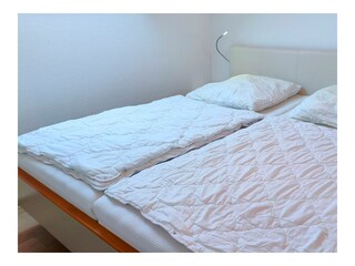 Schlafzimmer mit Doppelbett und TV