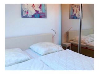 Schlafzimmer mit Doppelbett und Kleiderschrank