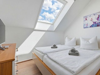 Schlafzimmer mit Doppelbett und TV