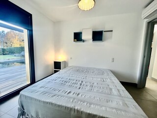 3. Schlafzimmer mit großem Bett und Gartenblick