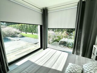 Blick zum Pool und in den Garten mit Schutzmarkisen