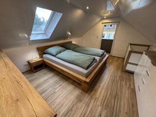 Schlafzimmer mit Doppelbett und Kinderbett