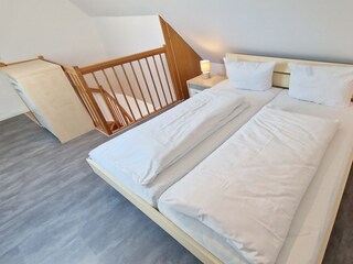 Schlafzimmer im Dachgeschoß mit Velux-Fenster und Verdunkelungsrollo