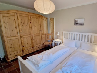 Schlafzimmer mit Doppelbett und grossem Kleiderschrank