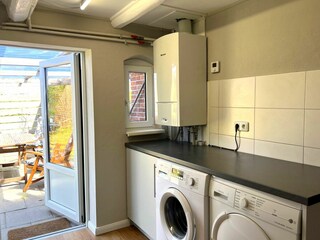 Hauswirtschaftsraum mit Waschmaschine und Trockner. Ausgang zur 2. Terrasse und hinterem Garten