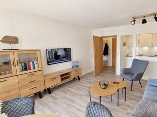 Wohnbereich mit abgetrennter Küche und Durchreiche.