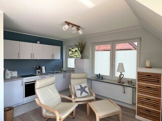 Sitzgruppe, dahinter die Küchenzeile