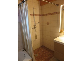 Badezimmer mit Badewanne und Dusche